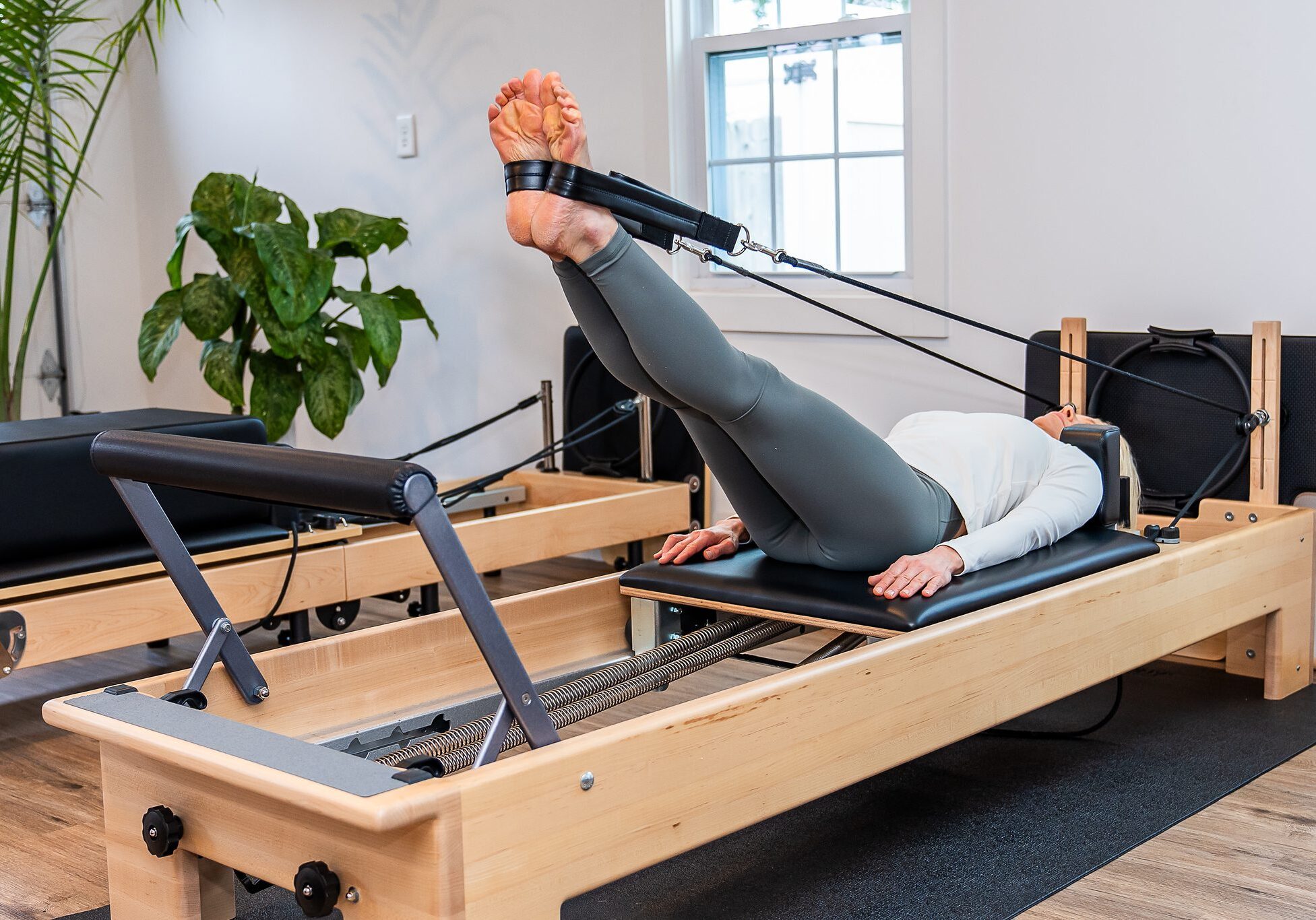 Person exercising on Pilates reformer machine