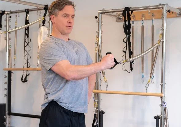 Person using Pilates reformer machine